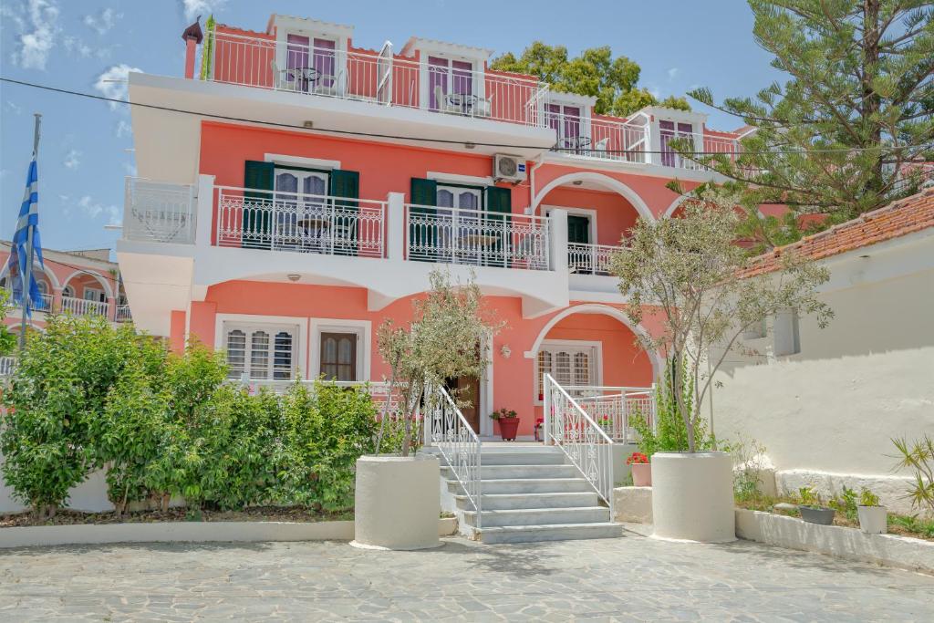 a pink building with stairs in front of it at Chryssa Studios in Argasi