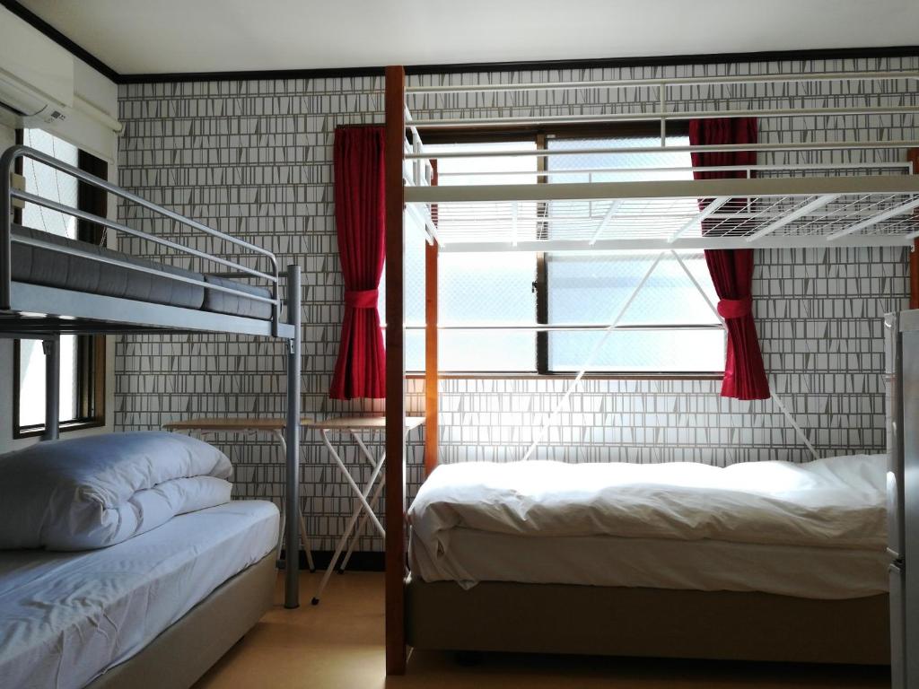 1 Schlafzimmer mit 2 Etagenbetten und einem Fenster in der Unterkunft COTE sakuragawa "Room 201,301,401" - Vacation STAY 03144v in Osaka