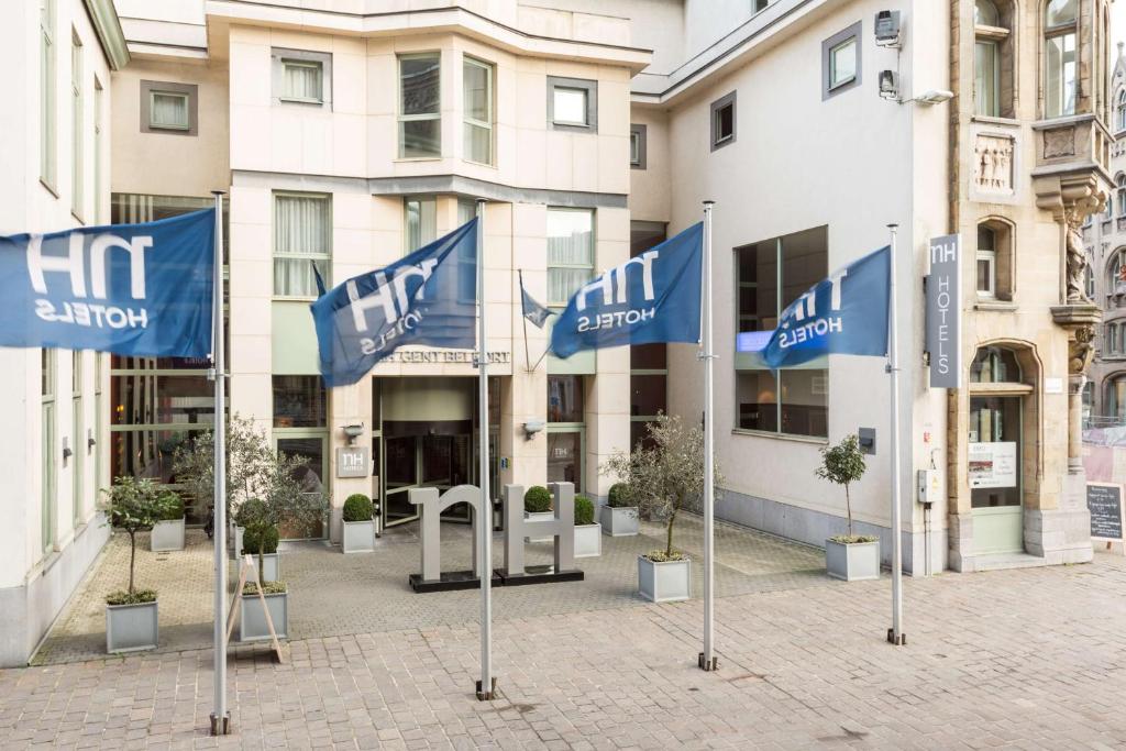 un groupe de drapeaux bleus devant un bâtiment dans l'établissement NH Gent Belfort, à Gand