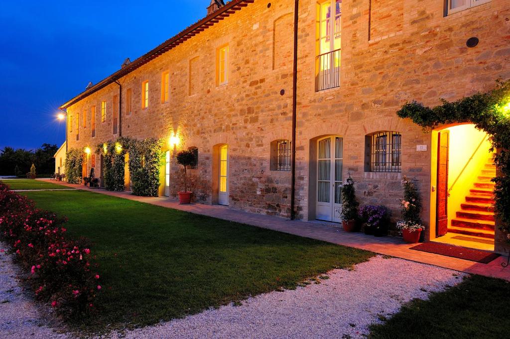 a large brick building with a lawn in front of it at Favorita Food&Wine Resort in Bastia Umbra