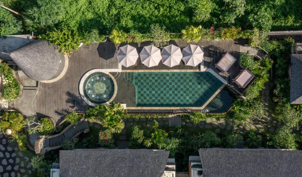 una vista aérea de una piscina con sombrillas en The Alena a Pramana Experience en Ubud