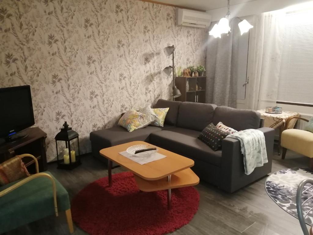 uma sala de estar com um sofá e uma mesa em Rivitalokaksio Jäppilässä em Jäppilä
