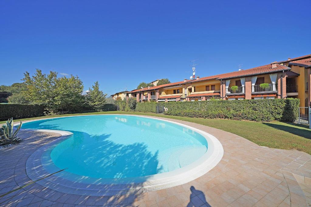 een groot zwembad voor een huis bij Appartamento la Goccia - Gardagate in San Felice del Benaco
