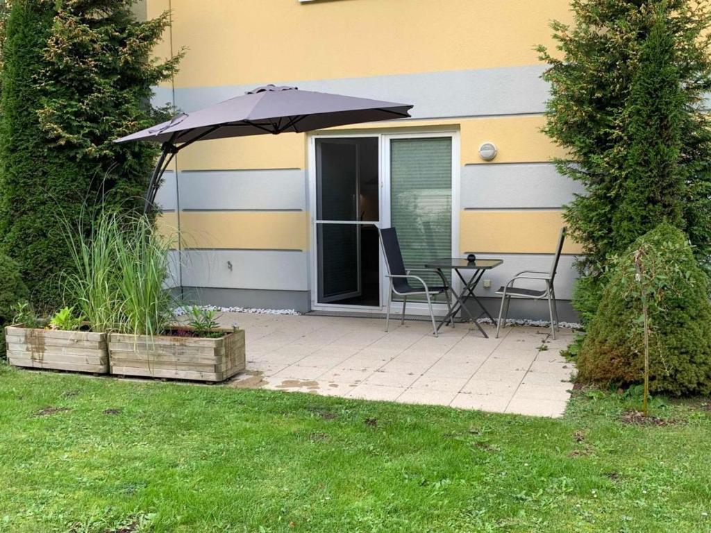 a patio with an umbrella and a table and chairs at Seebär in Gelbensande