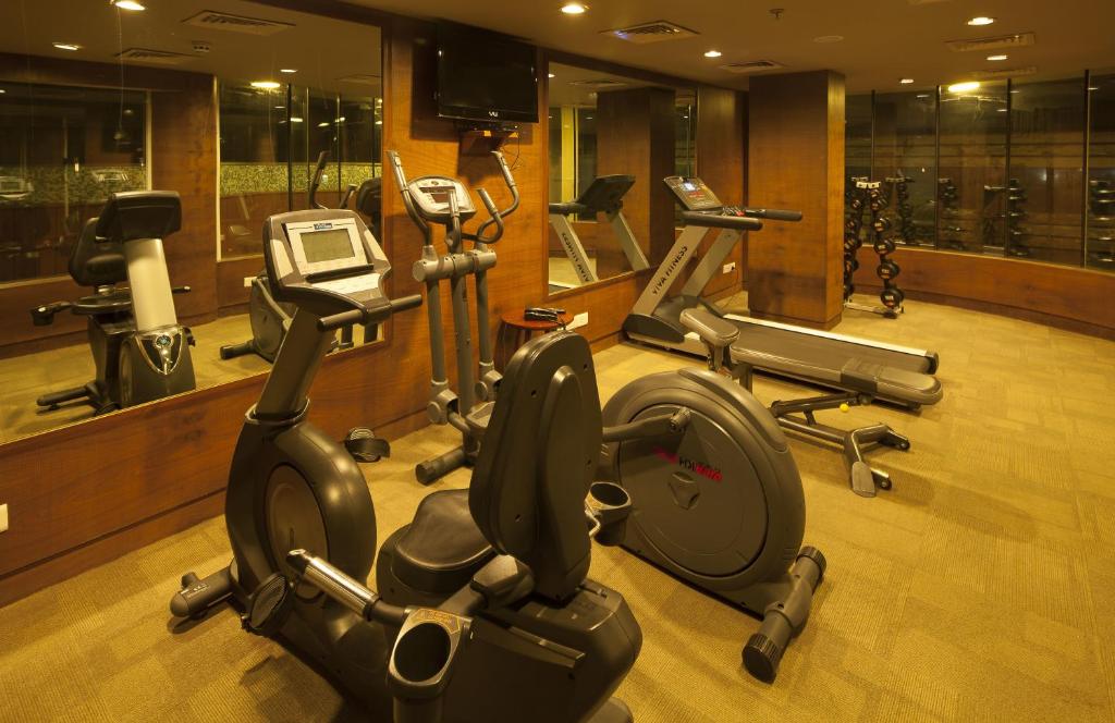 a gym with several cardio machines in a room at Vesta International in Jaipur