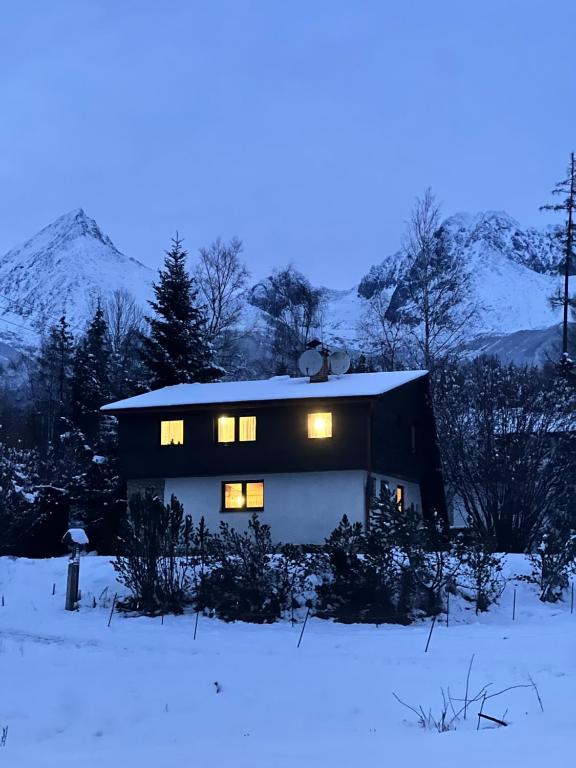 a house with lights on in the snow at Chata Tatranka in Štôla