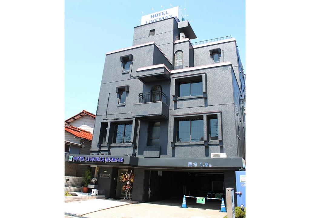 Uchinada的住宿－Hotel Livemax BUDGET Kanazawa-Idaimae，一座高大的灰色建筑,上面有标志