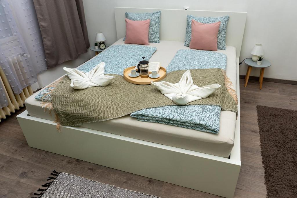 ein Bett mit zwei Kissen und einem Tablett mit Kaffeemaschinen drauf in der Unterkunft Wanderer 3 in Debrecen