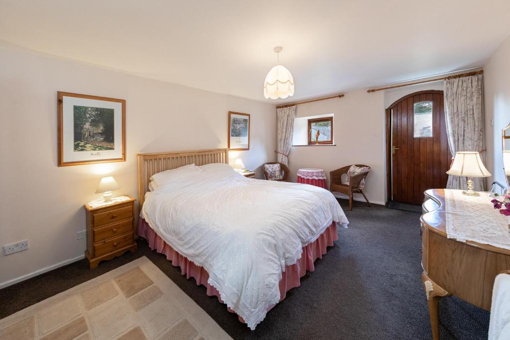 a bedroom with a large bed and a desk at Cobblestones Cottage at Lovelady Shield in Alston