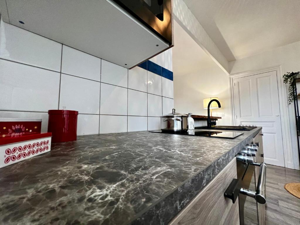 a kitchen with a marble counter top in a room at Home Sweet Home in Roanne