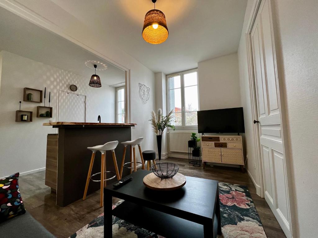 a living room with a table and a bar in it at Home Sweet Home in Roanne