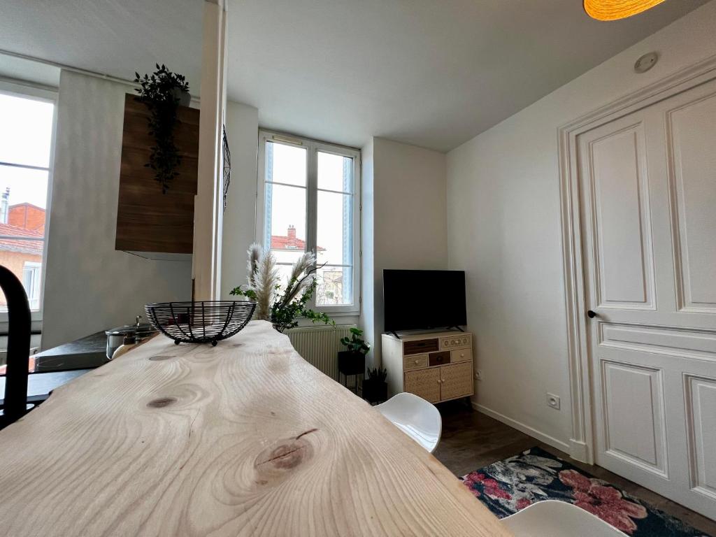 a large wooden table in a room with a tv at Home Sweet Home in Roanne
