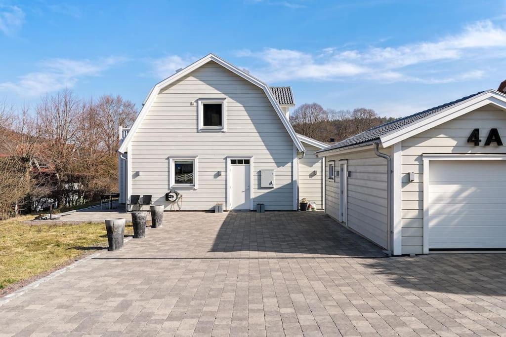 una gran casa blanca con garaje en Modernt hus med parkeringsplatser och trädgård en Gotemburgo