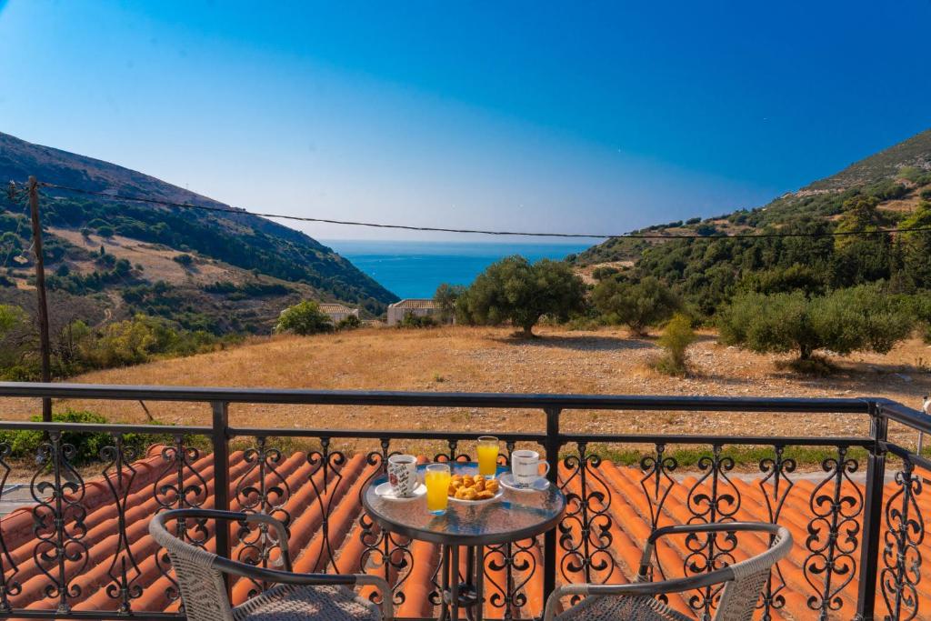 einen Tisch auf einem Balkon mit Meerblick in der Unterkunft Myrtos View Apartments in Anomeriá