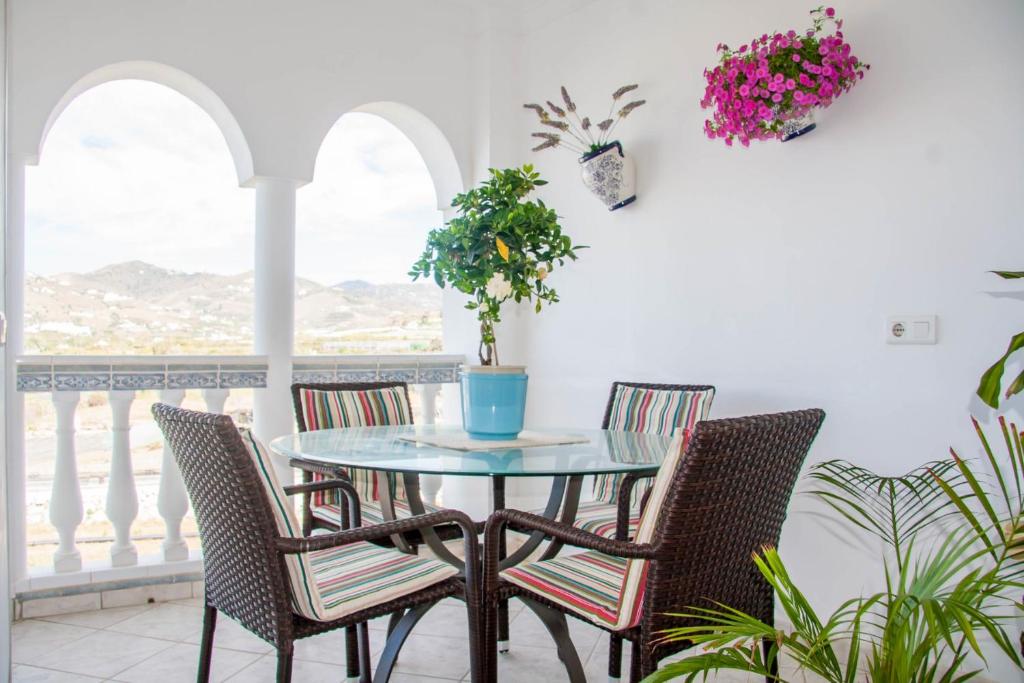 a table and chairs on a balcony with flowers at Stella Maris B4 3A Nerja in Nerja