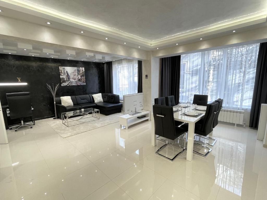 uma grande sala de estar com mesa e cadeiras em Luxury Central Apartment Verila em Sófia