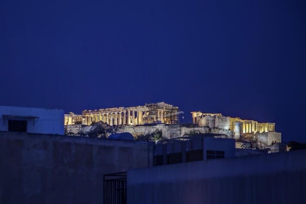 un edificio en la cima de una colina por la noche en Luxury Acropolis View Duplex Penthouse in Thiseio 155m2, en Atenas