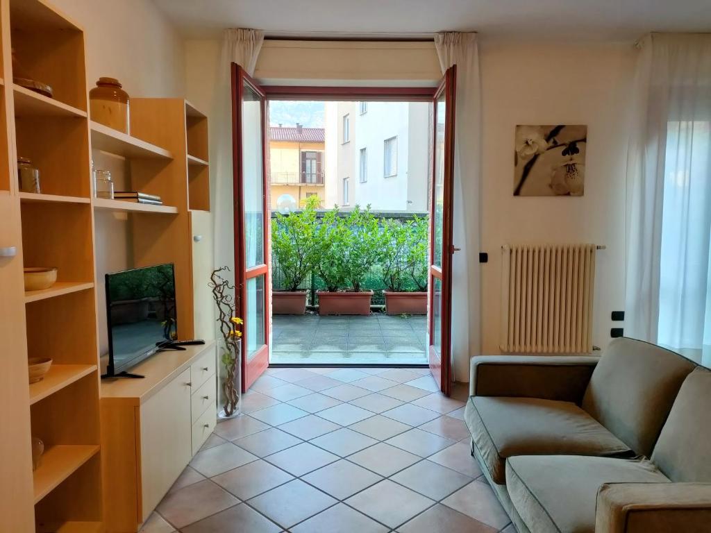 ein Wohnzimmer mit einem Sofa und einer Glasschiebetür in der Unterkunft La casa di Giovanni in Como