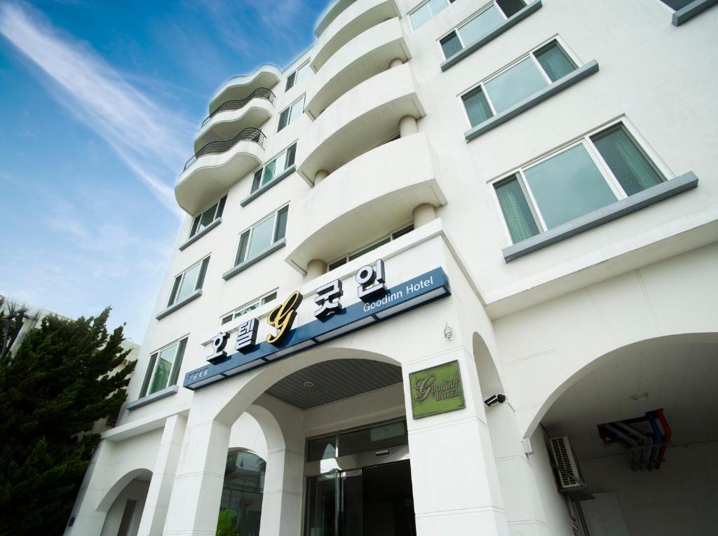 un edificio blanco con un cartel. en Hotel Good Inn, en Seogwipo