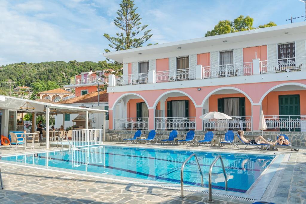 a hotel with a swimming pool in front of a building at Stella Studios in Argassi