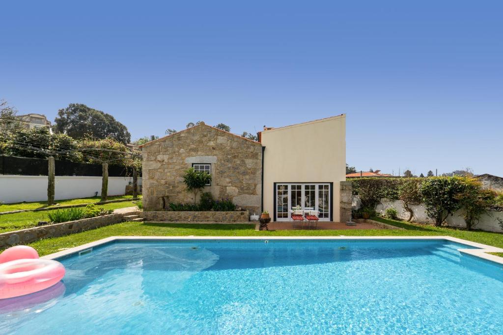 une villa avec une piscine en face d'une maison dans l'établissement Casa de S. Paio - 3 bedroom villa w/ pool & garden, à Braga