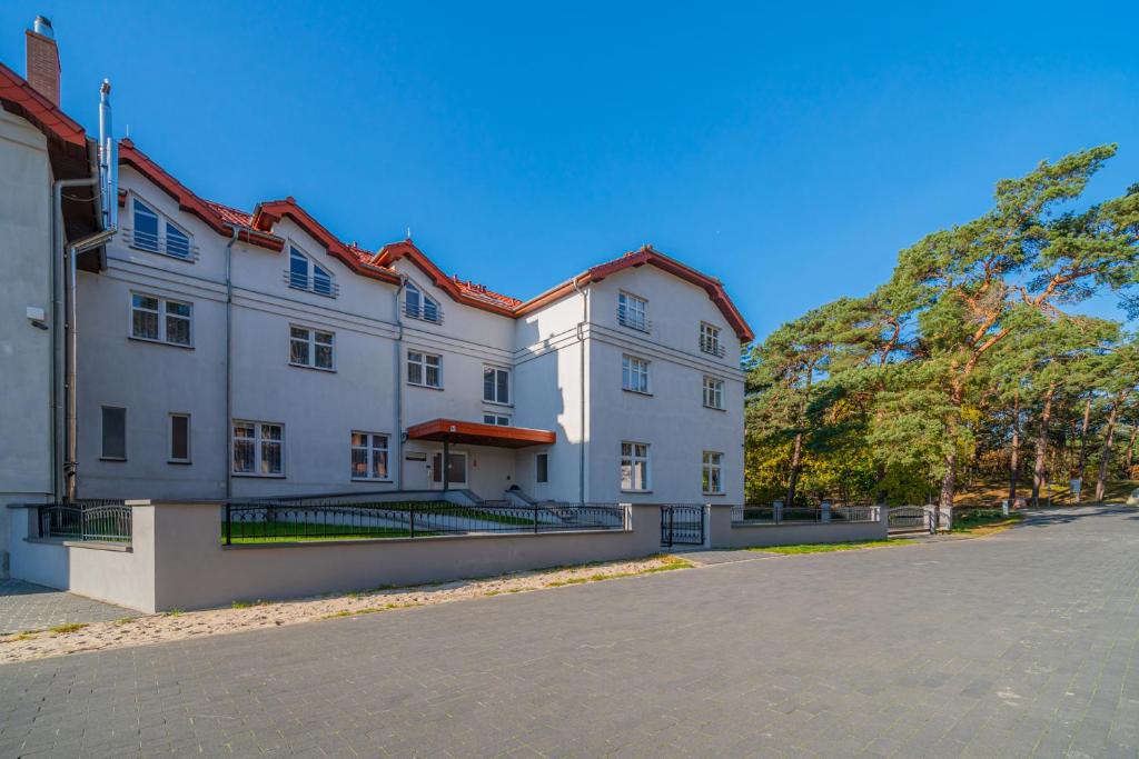 a large white building with a street in front of it at Nadmorski Dom Rekolekcyjny in Mrzeżyno