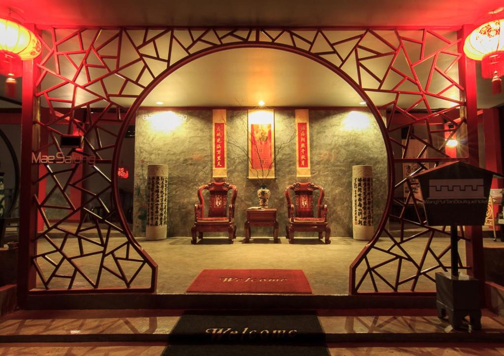 an archway with two chairs in a room at Wang Put Tan Boutique House in Mae Salong