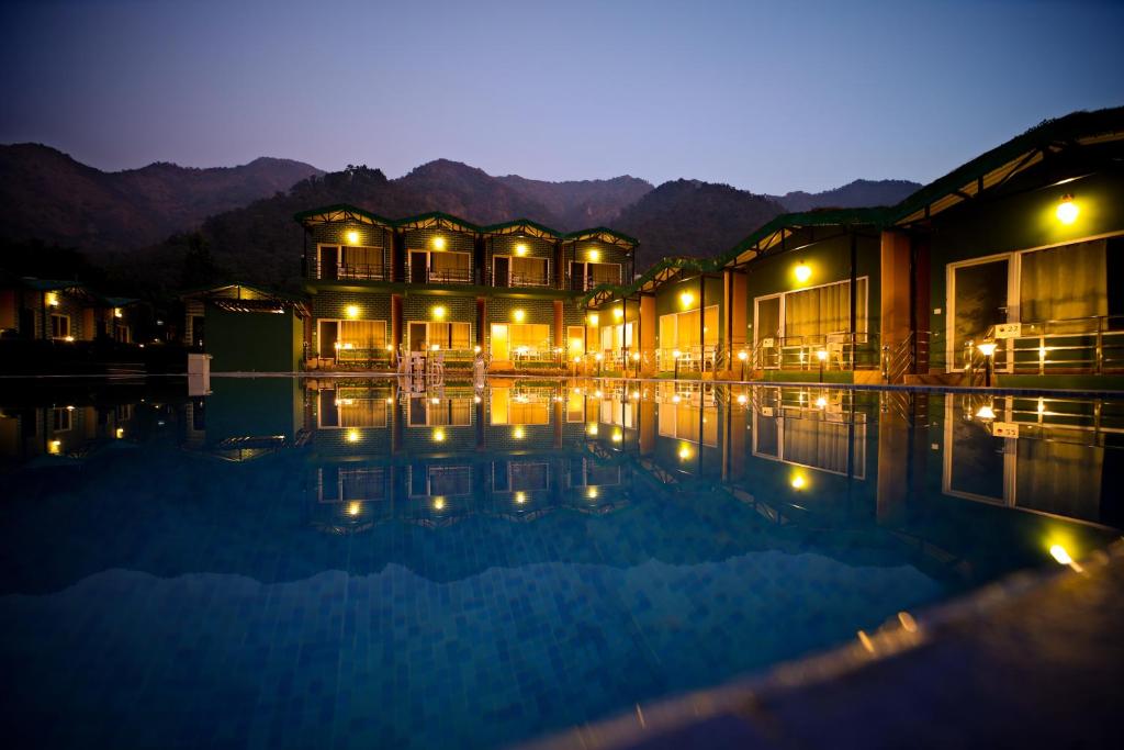 a building with a swimming pool at night at Camp Brook - Luxury Camping in Rishikesh in Rishīkesh