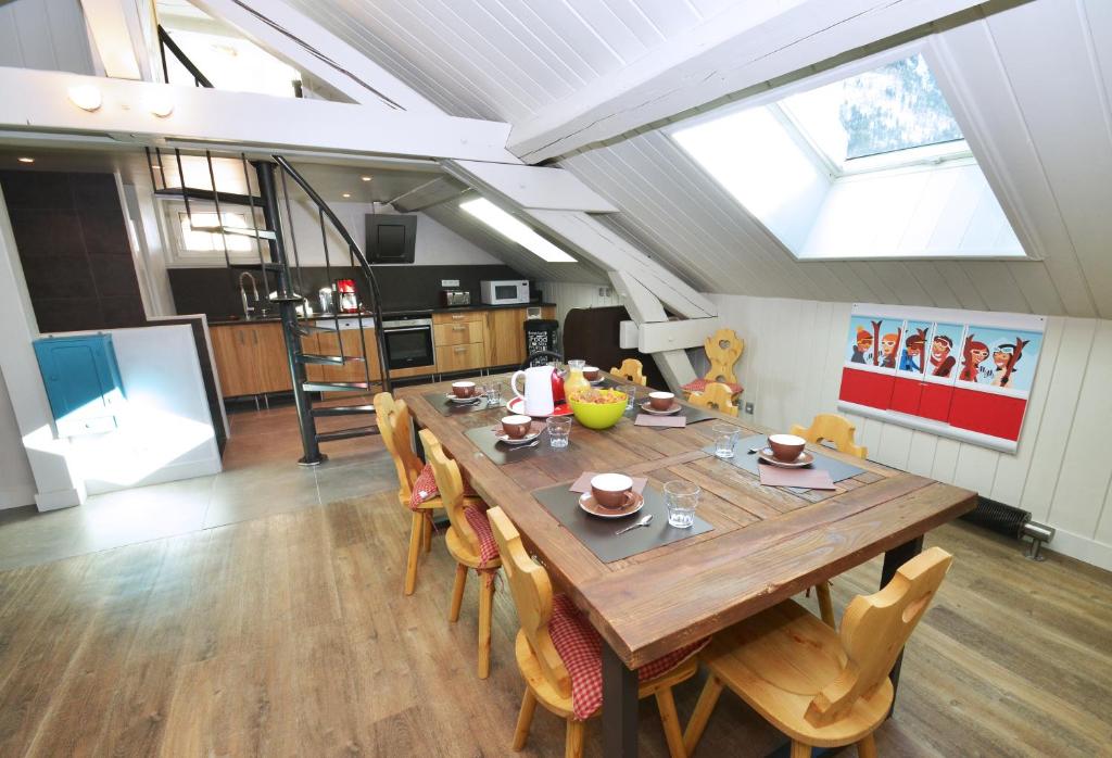 une cuisine et une salle à manger avec une table et des chaises en bois dans l'établissement Appartement Bellevue - centre ville, à Chamonix-Mont-Blanc