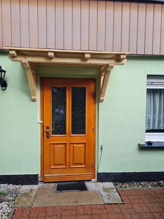 a wooden door of a house with a roof at Haus am Waldesrand in Tanne