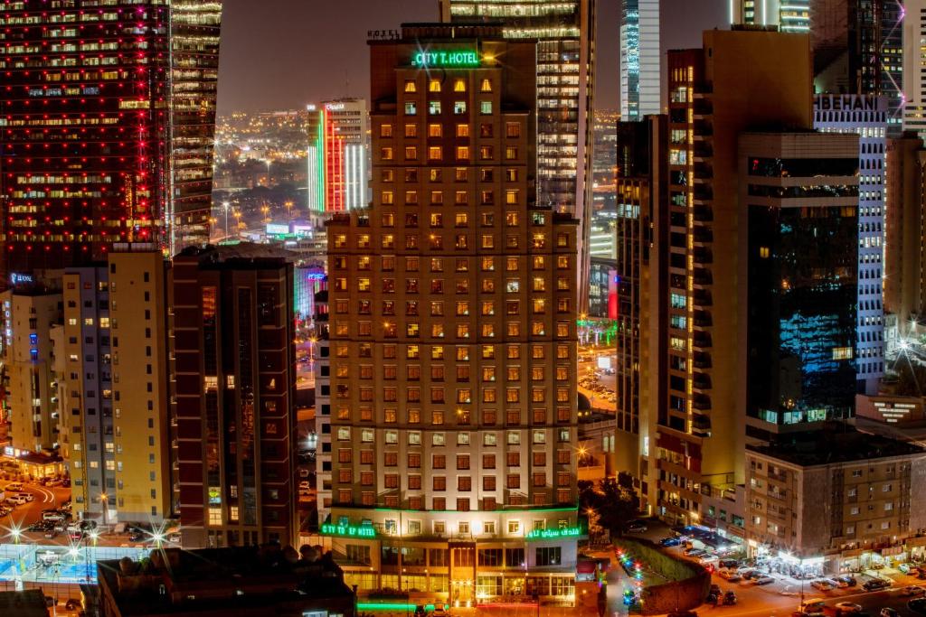 uitzicht op een stad in de nacht met gebouwen bij City Tower Hotel in Koeweit