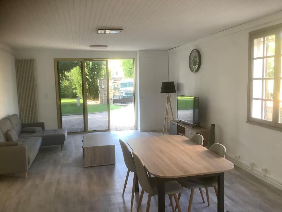 ein Wohnzimmer mit einem Holztisch und einem Sofa in der Unterkunft Le chant de la sorgue in LʼIsle-sur-la-Sorgue