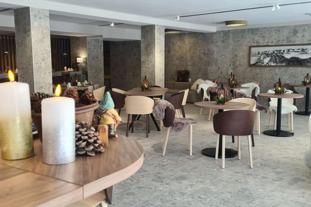 un ristorante con tavoli e sedie in una stanza di Luxury apartment with pool, sauna, SPA a Champoluc
