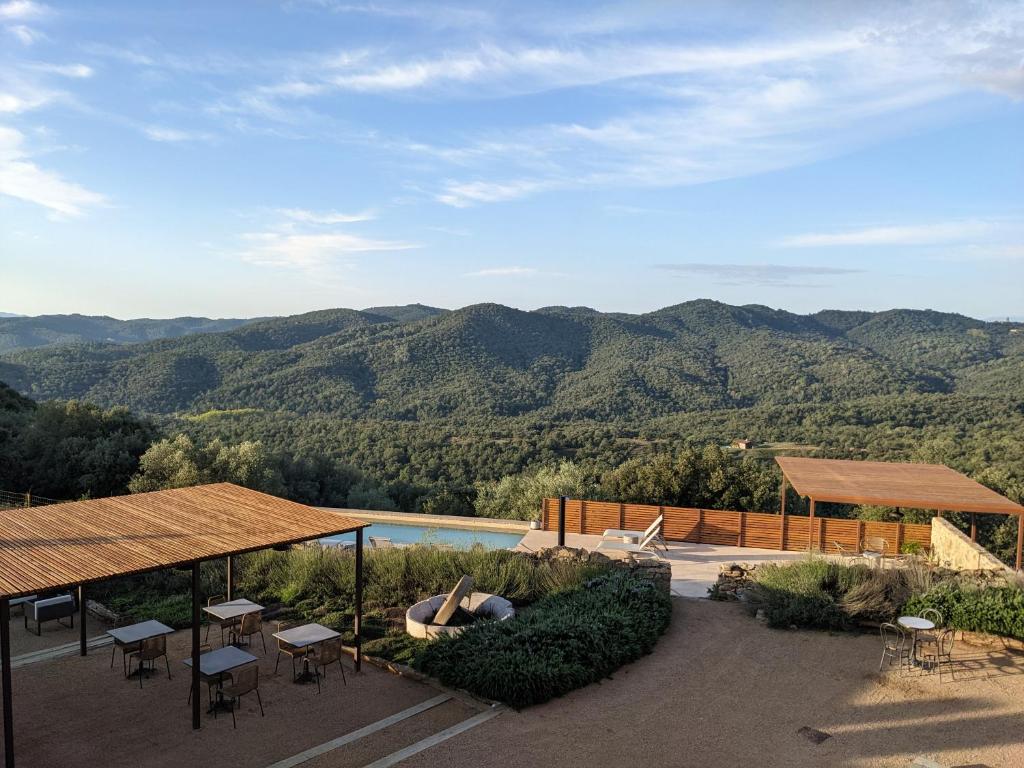 a resort with a pool and mountains in the background at Mas Oms in Montnegre
