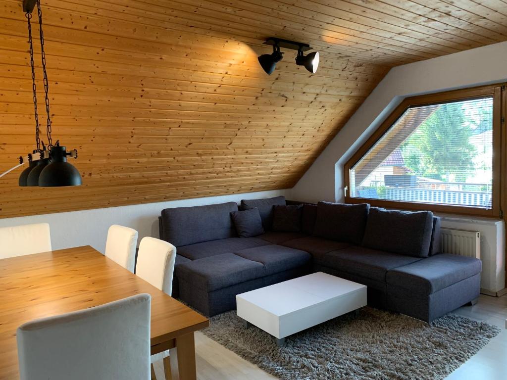 uma sala de estar com um sofá e uma mesa em Auszeit am Federsee em Bad Buchau