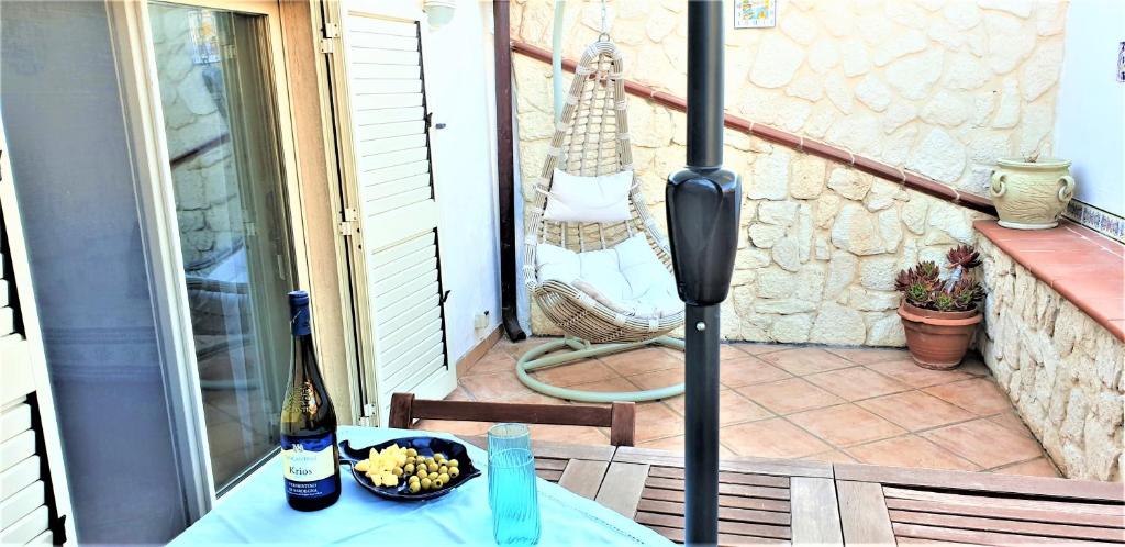 a table with a bowl of fruit and a bottle of wine at Casa Maria in Carloforte