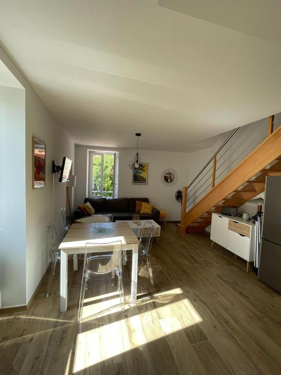a living room with a table and a staircase at Duplex en plein centre in Propriano