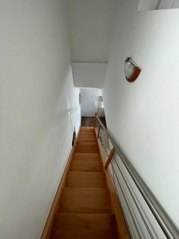 a staircase in a room with white walls and wooden floors at Duplex en plein centre in Propriano
