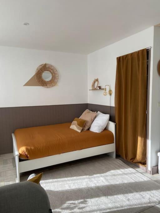 1 dormitorio con 1 cama con sábanas y almohadas de color naranja en Studio avec Balcon proche Gare, en Bourg-en-Bresse
