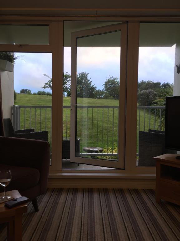 un porche con puertas correderas de cristal y vistas en Dawlish Warren Apartments, en Dawlish