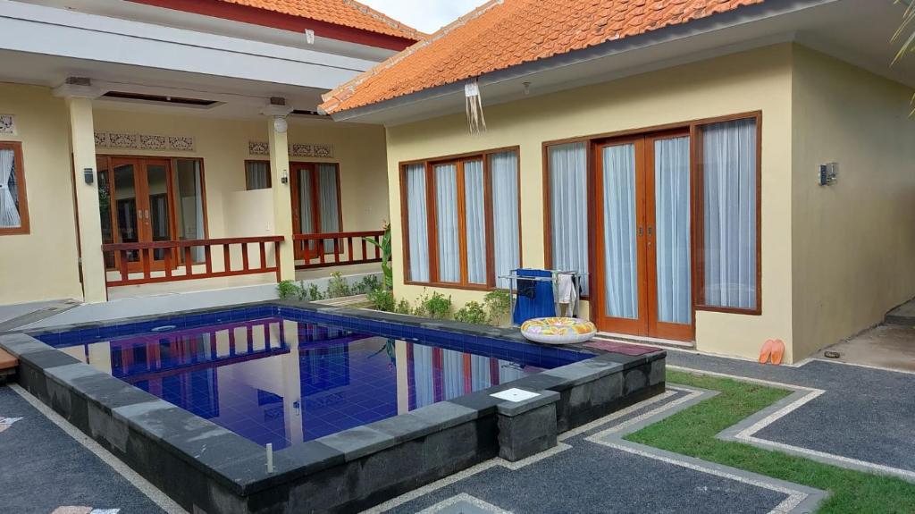 a house with a swimming pool in front of it at Pandawa Beach Homestay in Uluwatu