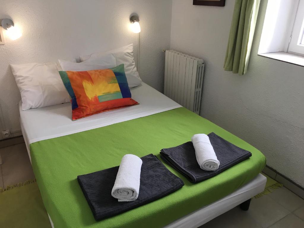 a bedroom with a bed with towels on it at Hotel Axat in Axat