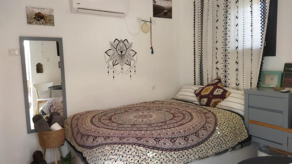 ein Schlafzimmer mit einem Bett mit einem Teppich darauf in der Unterkunft מקום קטן בשלווה a little peaceful place in Arad