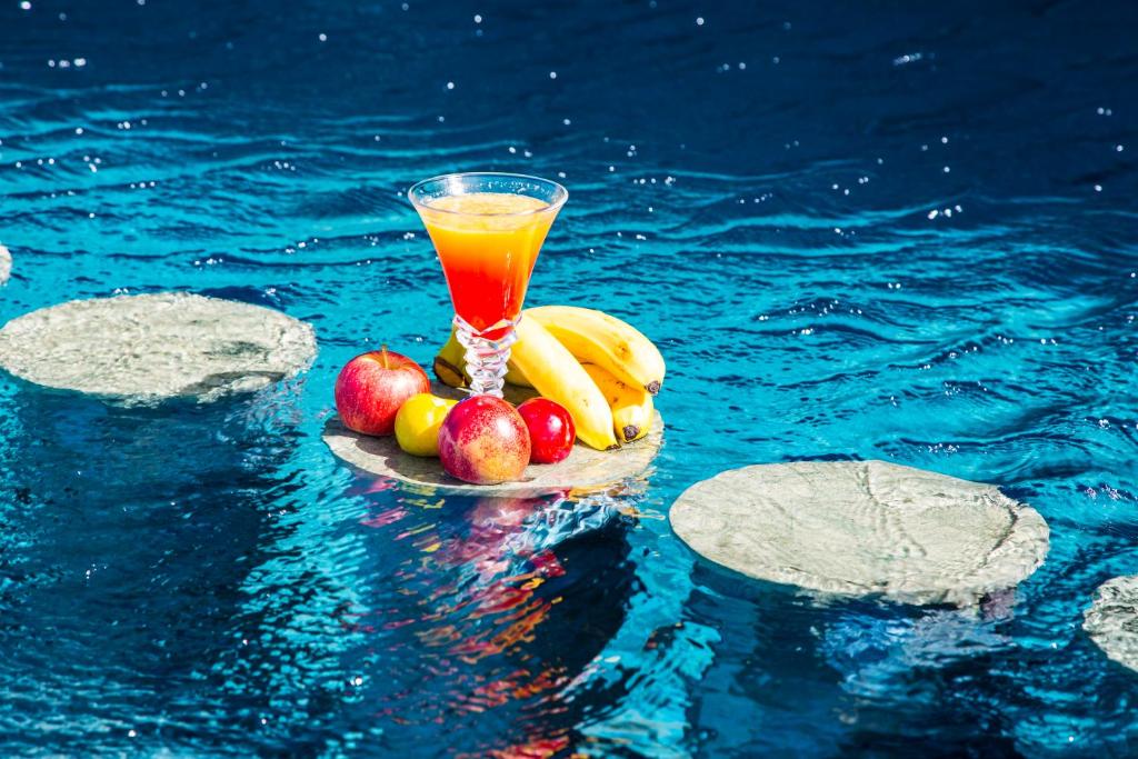 a glass of juice and fruit on a plate in the water at Valley Boutique Hotel in Safi
