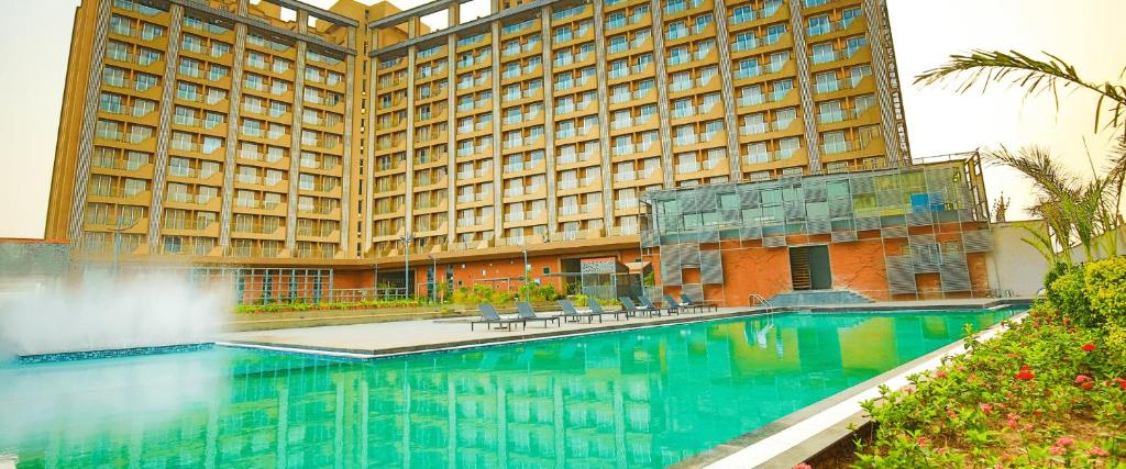 een hotel met een zwembad voor een gebouw bij WEEKEND ADDRESS by Guest Pals in Surat