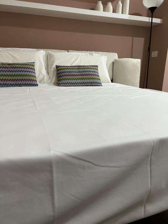 duże białe łóżko z 2 poduszkami w obiekcie Dalì Home w Katanii