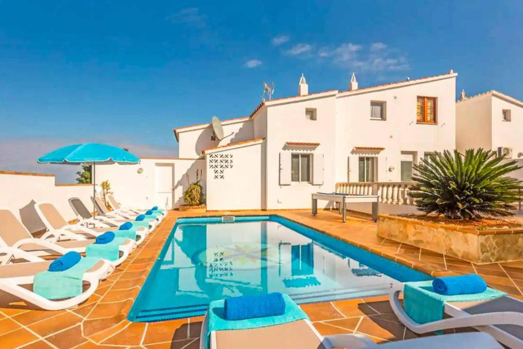 een villa met een zwembad en ligstoelen bij Vista Arenal in Arenal d'en Castell