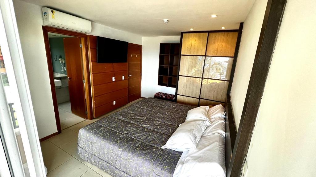 Dormitorio pequeño con cama y TV en Ap climatizado com vista mar no Rio Vermelho, en Salvador