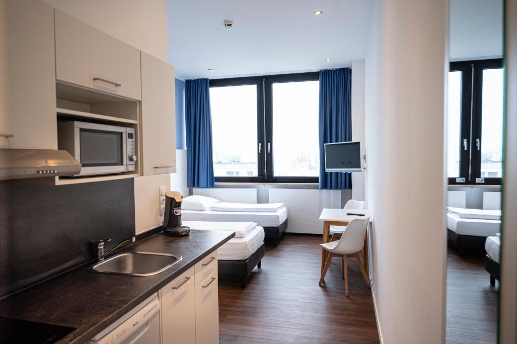 um quarto com uma cozinha e uma sala de estar em apartmenthaus international em Munique