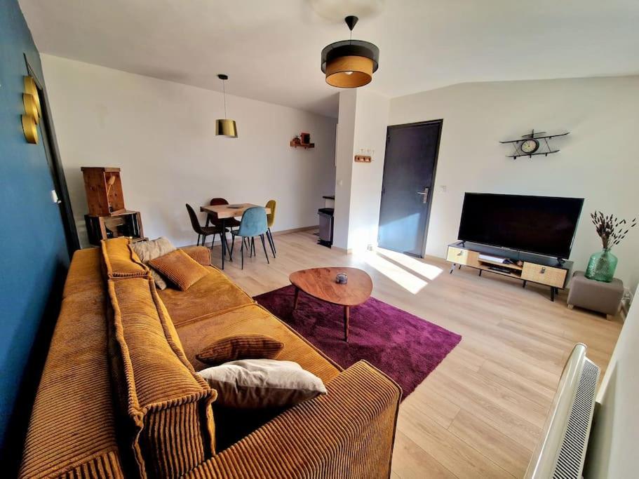 a living room with a couch and a table at Appartement l'Insolite in Vernet-les-Bains